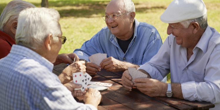 anziani che giocano a carte rallentando il declino cognitivo